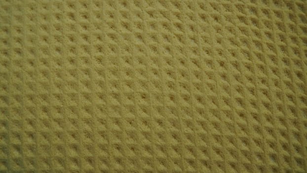 Sponge fibers sponge texture pattern surface close-up yellow brown background.