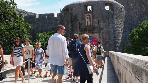 Pile Gate Dubrovnik Croatia August 14 2022 People men and women walk along the stone bridge to the gate of the Old City. Crowd of tourists. Busy entrance. The main entrance to Old Town, busy Pile Gate