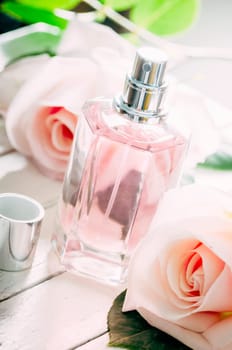Bottle of perfume and pink wedding roses bouquet decoration.