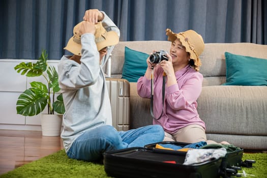 Travel and tourism. Asian couple old senior marry retired couple smiling taking photo by camera during luggage suitcase arranging for travel, Happy mature retired couple photography weekend holiday
