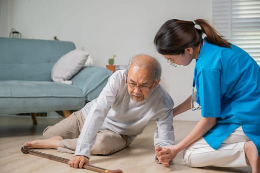 Asian older senior man falling down on lying floor and woman nurse came to help support, Disabled elderly old man patient fall down and caring young assistant at nursing home