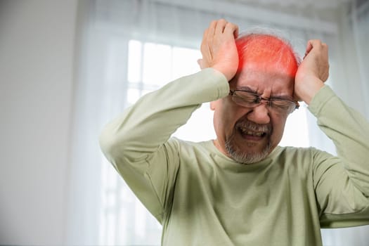 Headache. Sad Asian senior man chronic migraine pain massaging, old man holds head with hand for headache disease in living room at home, Old age health problems, healthcare