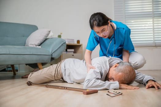 Disabled elderly old man patient with walking stick fall on floor and caring young assistant at nursing home, Asian older senior man falling down on lying floor and woman nurse came to help support