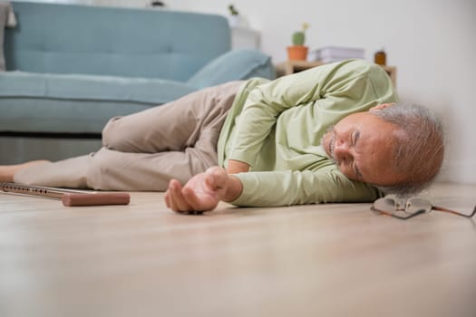 Older senior man headache lying on the floor after falling down he pain and hurt from osteoporosis, Elderly man falling on the floor alone with walking stick at home, Health care and medicine