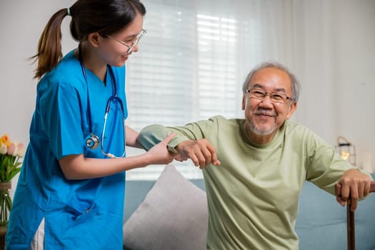 Young woman help support orthopedic patients to get up with walking cane at home, Caring nurse helping supporting senior disabled man to stand up with walking stick, International Day for the Elderly