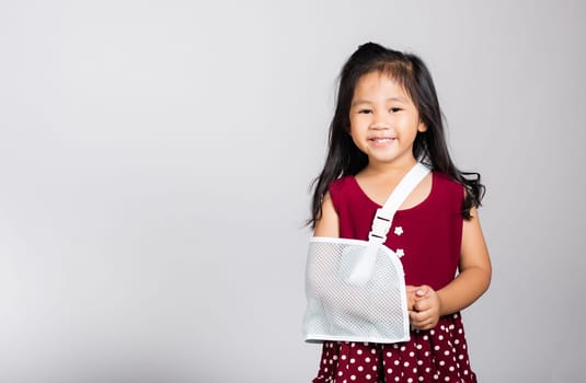 Arm broken. Little cute kid girl 3-4 years old hand bone broken from accident with arm splint in studio shot isolated on white background, Asian children preschool injured after accident, health