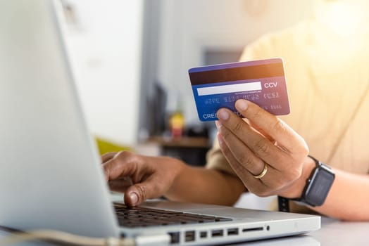Online shopping. Woman hands holding credit card and using laptop with product purchase at home, female register via credit cards on computer to make electronic payment security online