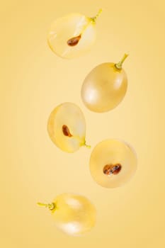 Isolated flying grapes. Five whole and sliced grape fruits falling on white with clipping path as package design element and advertising. Full depth of field.