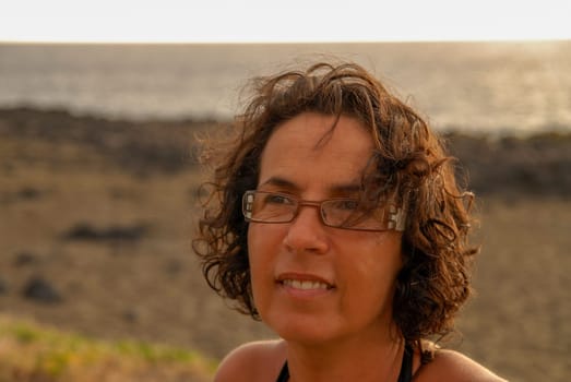 a portrait of beautiful brunette mature woman with eyeglasses