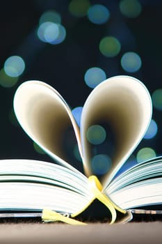 opened buck with sides that are beaten to the heart. Light spot by fairy lights in background with soft bokeh. Love novel for romance.