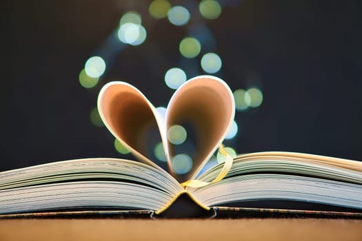 opened buck with sides that are beaten to the heart. Light spot by fairy lights in background with soft bokeh. Love novel for romance.
