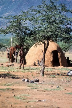 May 15, 2005.Himba village. unidentified Himba women with the traditional hairstyle, necklace and the typical ochre tinted skin. Epupa Falls, Kaokoland or Kunene Province, Namibia, Africa.