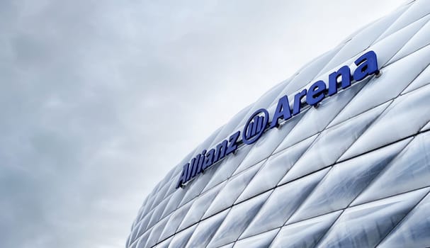 Munich, DE, Dec 2022: view of the exterior of the Allianz Arena in Munich on a cloudy day. The membrane covering the stadium illuminates in different colors depending on the event taking place inside.