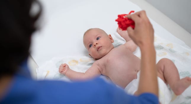 Baby lying on his back as his doctor examines him during a standard medical checkup.