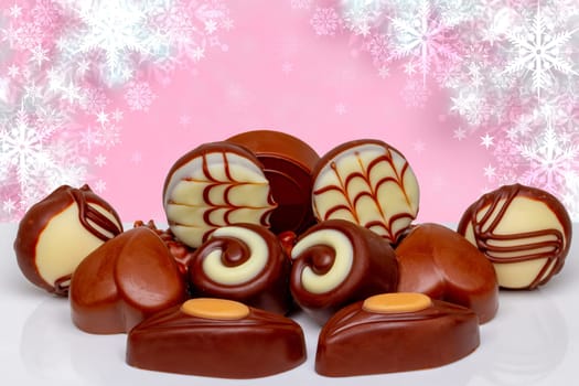 Chocolate candy collection. Beautiful assortment of expensive Swiss chocolate truffles and praline sweets on table over abstract festive background. Copy space.
