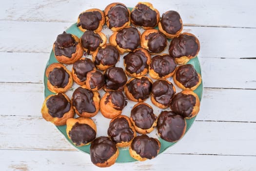 delicious little chocolate cream puffs on wooden table