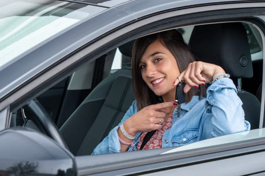 pretty young brunette driving a car