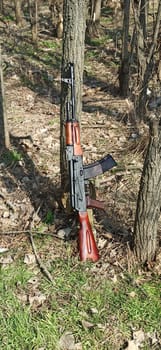 kalashnikov assault rifle ak74n standing at the tree. AK-74. Assault rifle. Soviet weapon. Assault rifle of struggle. Equipment for the war. AK-74 outdoor