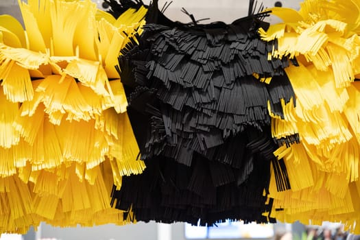 front view closeup detail of black and yellow automatic car wash system cleaning fiber sponge brushes on spinning rotor