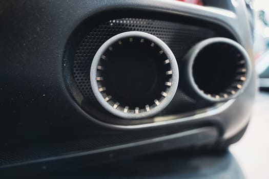 detail rear view of black sport car pair of exhaust pipes with dark mesh grill