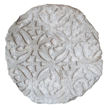 front view closeup of large round plaque of antique stone carved with floral pattern and ragged edges isolated on white