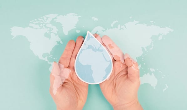Holding a water drop in the hands, silhouette of world map, environment issue, scarcity of resources, world water day