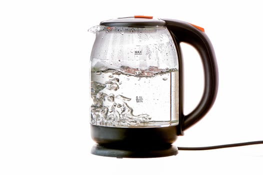 Glass electric kettle with boiling water on a white insulated background. High quality photo