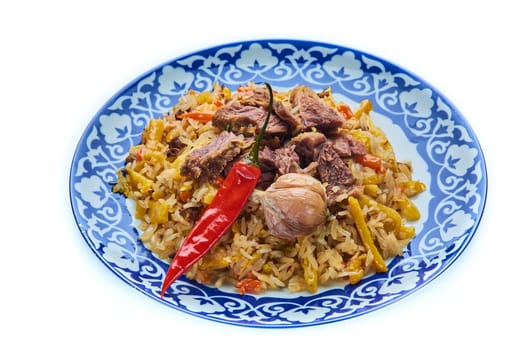 Delicious Uzbek festive pilaf in a plate on a white isolated background. High quality photo
