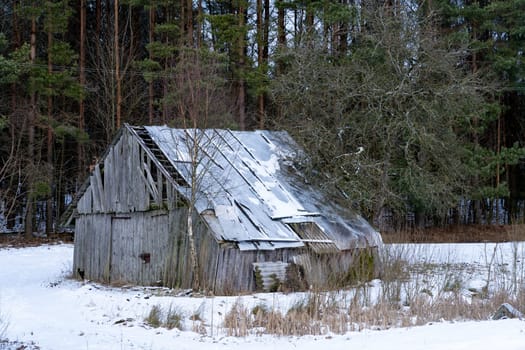 Old barn in the village on a winter day