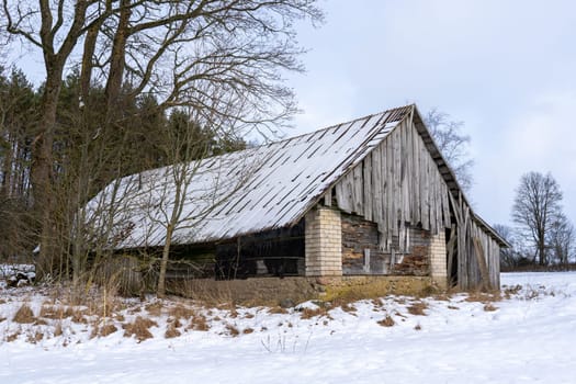 Old barn in the village on a winter day