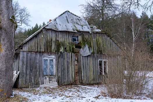 Old wooden abandoned and ruinous country house in rural