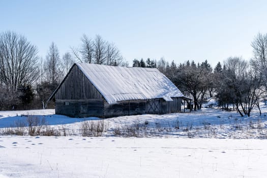 Old barn in the village on a winter day