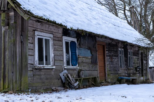 Old wooden abandoned and ruinous country house in rural