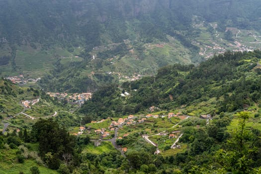 Aerial view on small city Sao Vicente - Chapel on the hill, huge mountains on background. Madeira island, Portugal.