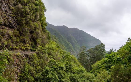 Mountain hiking trail in Madeira mountains. Footpath is running along the mountain slope.