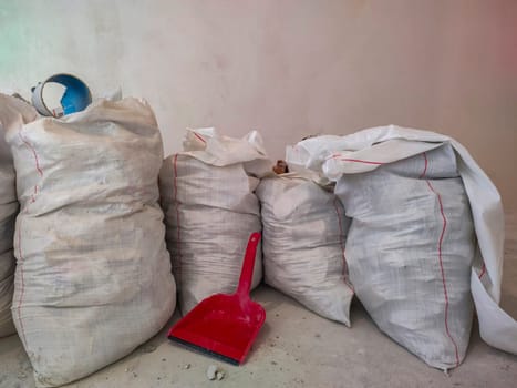 White polypropylene construction bags and scoop for garbage collection. Polypropylene bag. Construction waste. Repair of apartments. Industrial waste. Scoop for garbage collection.