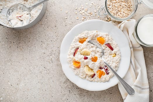 Oatmeal plate. A plate of oatmeal served with fresh fruit and milk. Healthy food, diet. Top view.
