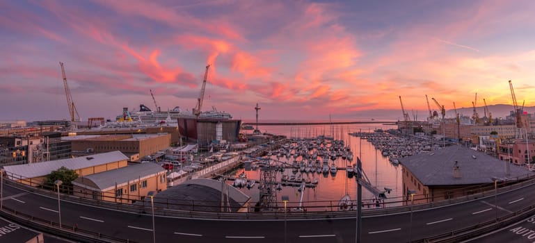Genoa, Italy - 06 26 2021: Genoa Port Yacht Club at sunset with boats and cranes.