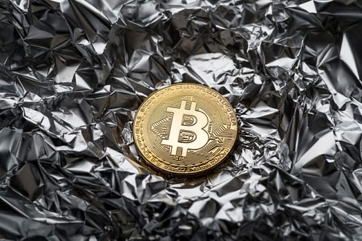 Golden coin with bitcoin symbol close up. Bitcoin and cryptocurrency investing concept. Bitcoin cryptocurrency coin. Trading on the cryptocurrency exchange. Trends in bitcoin exchange rates.