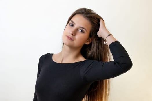 Portrait of attractive long haired girl on the light background. Horizontally.