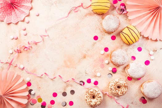 Traditional Berliner for carnival and party. German Krapfen or donuts with streamers and confetti. Colorful carnival or birthday image