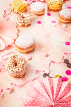 Traditional Berliner for carnival and party. German Krapfen or donuts with streamers and confetti. Colorful carnival or birthday image