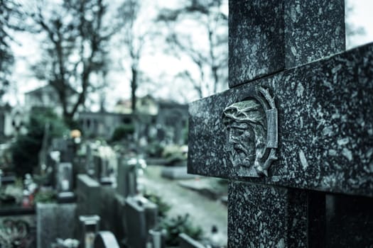 Marble cross in cemetery. Tomb decoration. Memorizing loved ones. Tombstones and a chapel in the public cemetery