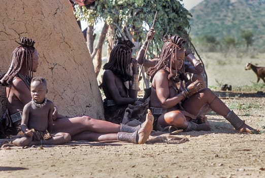 May 15, 2005.unidentified Himba women and their children with traditional hairstyle, necklace and typical ocher skin. Epupa Falls, Kaokoland or Kunene Province, Namibia, Africa