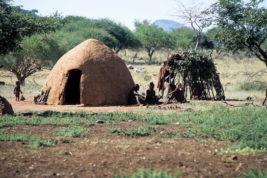 May 15, 2005.Himba village. unidentified Himba women with the traditional hairstyle, necklace and the typical ochre tinted skin. Epupa Falls, Kaokoland or Kunene Province, Namibia, Africa