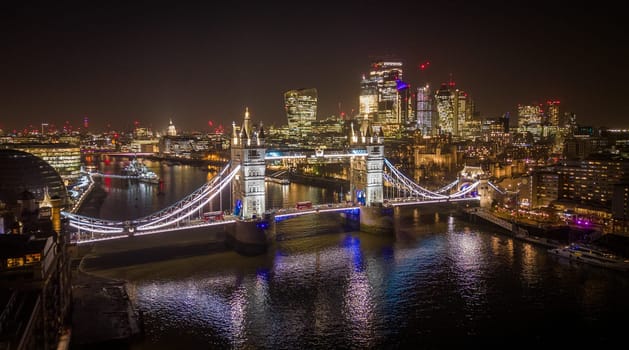 London Tower Bridge and City of London by night - amazing aerial view - LONDON, UNITED KINGDOM - DECEMBER 20, 2022