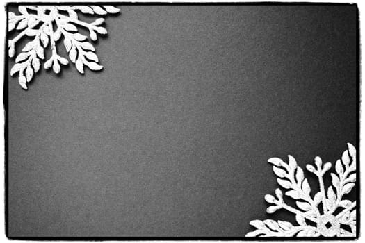 Christmas background with snowflakes. On a black-and-white background two silver-white snowflakes with sparkles are laid out. Happy New Year. Merry Christmas frame. Postcard or invitation. Copy space