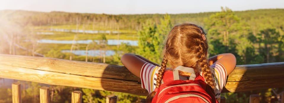 Girl standing on the observation tower on the Viru bog. Concept of the family vacation and camping.