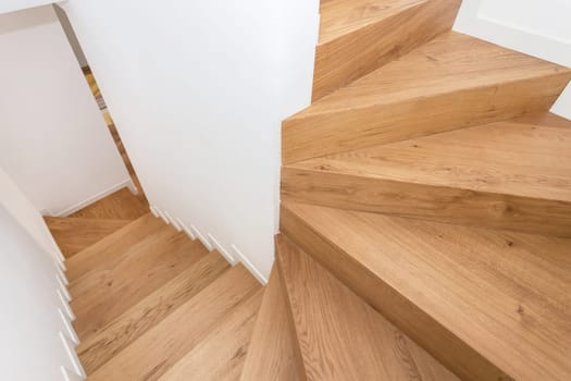 Modern residential wooden stairs. Wood staircase inside contemporary white modern house.