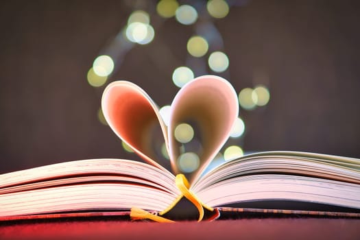 opened buck with sides that are beaten to the heart. Light spot by fairy lights in background with soft bokeh. Love novel for romance.